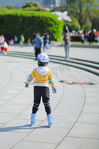 玩耍的小朋友摄影照片_公园滑冰的小孩摄影图配图
