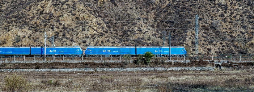 铁路钢轨摄影照片_行驶中的电力火车上午火车山区素材摄影图配图