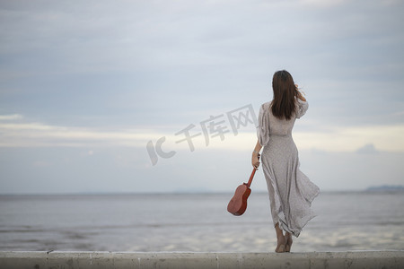 古代女子梨花带雨摄影照片_海边女子背影摄影图配图