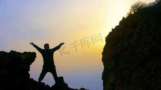 跨年徒步摄影照片_男人登山攀登山峰悬崖意境人物剪影