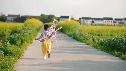 风筝春游摄影照片_春天儿童男孩奔跑的背影