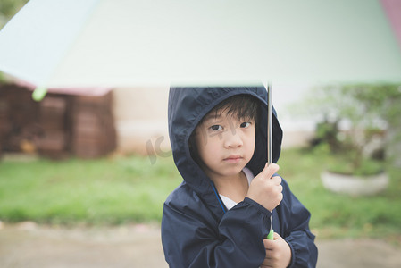人物形象母婴儿童快乐的亚洲男孩抱着五颜六色的伞