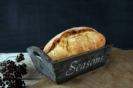 黑色美食海报摄影照片_在木桌上的面包