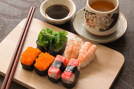 手绘寿司店摄影照片_设置用筷子和酱油寿司饭木石板上 