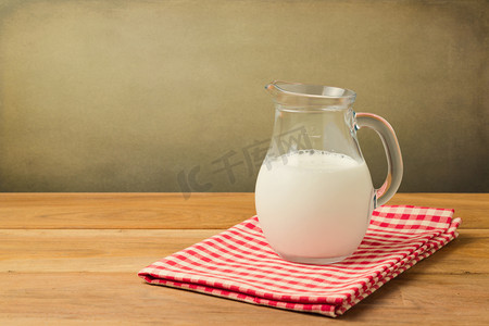 广告海报摄影照片_牛奶投手在桌布上了 grunge 背景