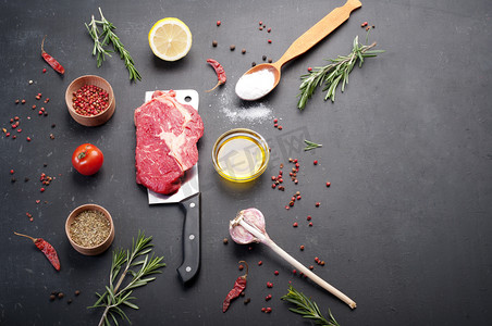 黑椒牛肉味摄影照片_生牛肉牛排，放在切刀上。为烹饪牛排准备的生牛肉。除了烹饪牛排、香料和香草的配料.
