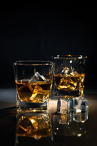 金色的闪光光源摄影照片_威士忌加冰块