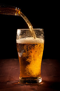 抖音抖音啤酒摄影照片_鲜啤酒从瓶涌入玻璃