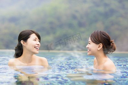 高兴开心风景摄影照片_幸福的年轻女人在温泉中休息