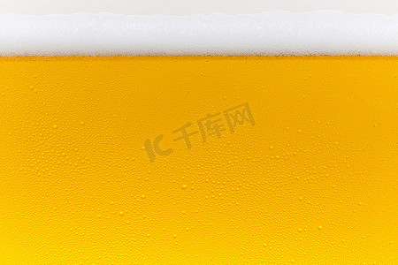 冠摄影照片_啤酒露珠啤酒泡沫玻璃的金冠泡沫波慕尼黑啤酒节冷凝啤酒餐厅 pils
