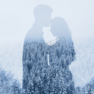 雪摄影照片_对森林背景夫妇的剪影,