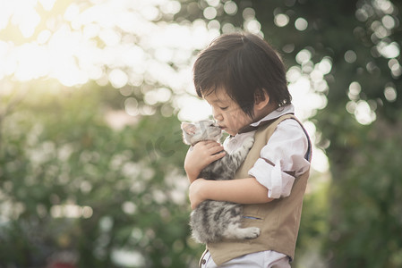 抱抱摄影照片_亚洲男孩亲吻美国短毛小猫 