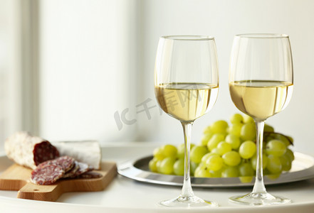 与白色葡萄酒及葡萄在桌子上的眼镜