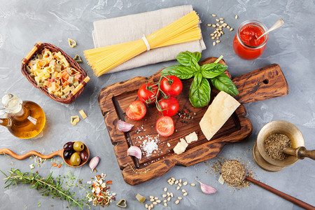 西红柿番茄摄影照片_意大利食品背景，葡萄番茄，罗勒，意大利面，橄榄，香菜，橄榄油，大蒜