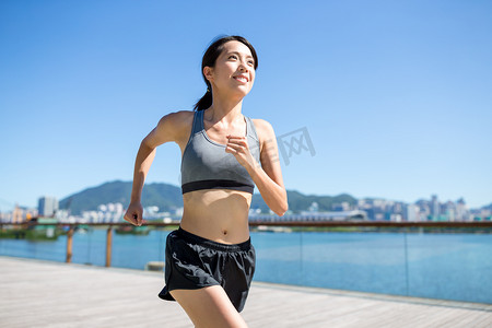 女人在海滨步道上运行