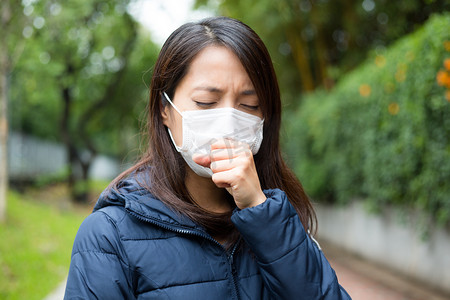亚洲的年轻女人生病，戴着口罩