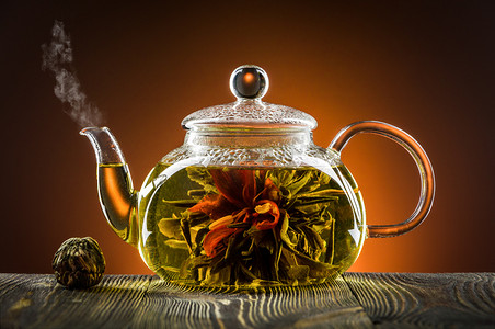 玻璃茶壶配茶花朵木制的桌子上