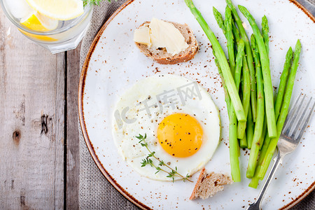 浪漫晚餐摄影照片_绿芦笋、 煎的鸡蛋和黄油涂面包上.