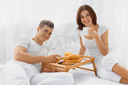 portrait摄影照片_Portrait of couple enjoying breakfast in bed