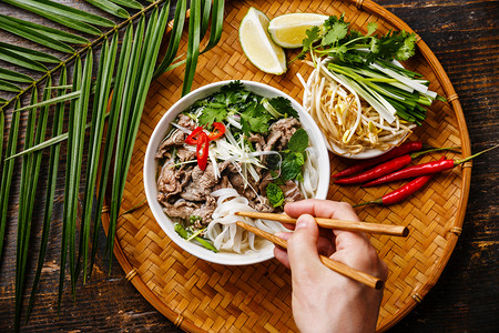 越南摄影照片_汤和男性手中的筷子