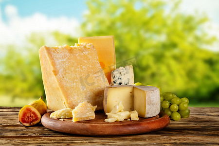 cheese摄影照片_各种类型的奶酪放在木桌