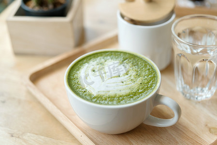 咖啡店木桌上的绿色热茶