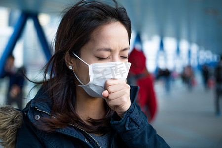 公共厕所戴口罩摄影照片_戴着口罩咳嗽的女人