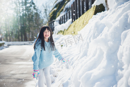 亚洲女孩在雪中户外微笑在寒冷的冬天里