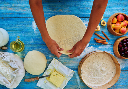 full摄影照片_Young girl chef kneads  and rolling the dough with pin