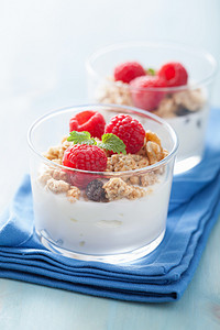 吃酸奶摄影照片_健康的早餐酸奶麦片和覆盆子 