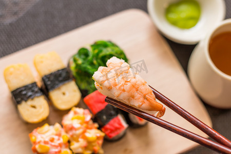 鱼豆腐鱼摄影照片_寿司用筷子，设置送达木制板岩，选择性的芥末