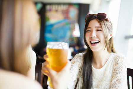 幸福的年轻女人祝酒在餐厅喝