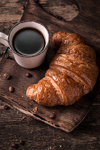 咖啡和木制的老式桌子上牛角面包一起吃早餐