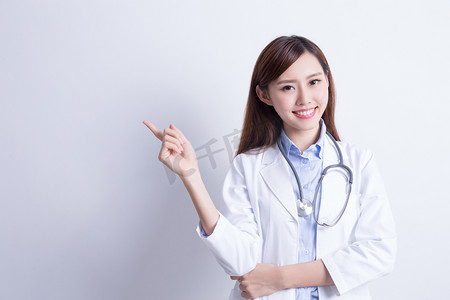 常见病预防摄影照片_穿着白卦手指上方自信微笑的女医生