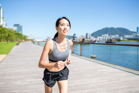 女人在海滨步道上运行