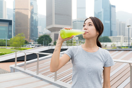 香港回归了摄影照片_运动型女人喝蔬菜汁饮料