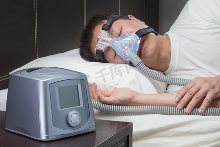 古人枕头摄影照片_亚洲人与睡眠呼吸暂停使用 Cpap 机