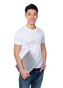 教育摄影照片_穿着白色 t 恤手拿笔记本的亚洲英俊的男人