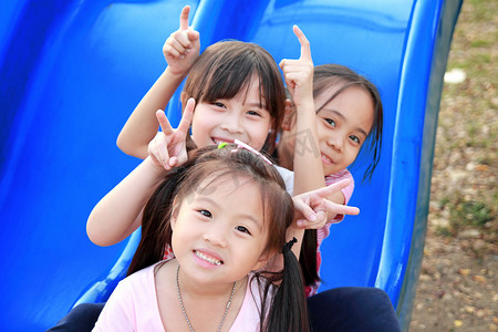 孩子们的房间摄影照片_三个快乐微笑着孩子们在公园玩