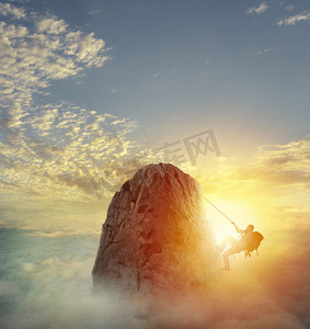 高端大气商务蓝色摄影照片_商人攀爬一座山攀登克服困难