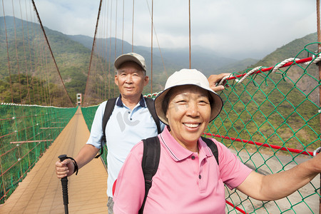 幸福的亚洲高级夫妇自然 pa 在桥上走