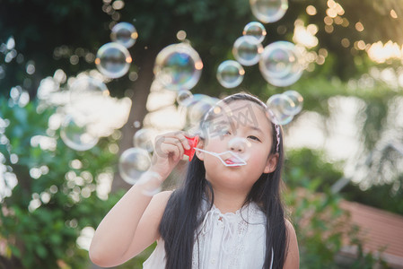泡泡玛特摄影照片_可爱的亚洲女孩在吹泡泡