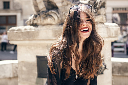 黑发模特摄影照片_快乐的时尚女人灿烂的笑容城市街头模特