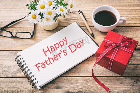 Red gift box and happy fathers' day on the notebook, office desk background