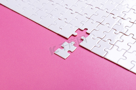 粉红kt板摄影照片_粉色背景的白色拼图。丢失的一块。顶部视图