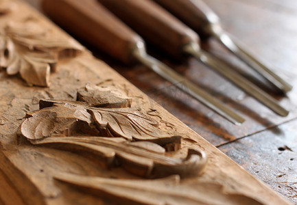招商手册摄影照片_在旧的风化木制工作台上雕刻木匠木凿工具