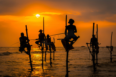 柬埔寨渔民与鸟摄影照片_传统渔民在日落时在斯里兰卡的剪影