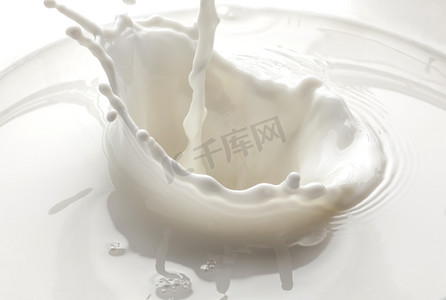 吃酸奶摄影照片_倒牛奶溅在白色背景上孤立