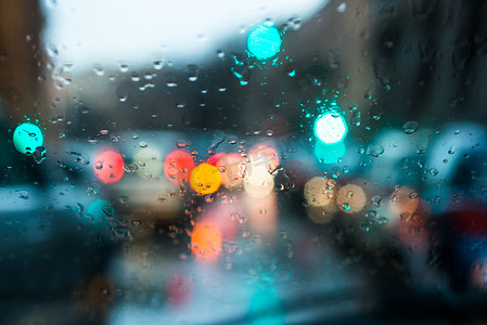 雨滴底纹摄影照片_模糊的光线，通过湿的挡风玻璃