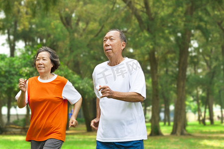 快乐的年长夫妇一起在公园里跑